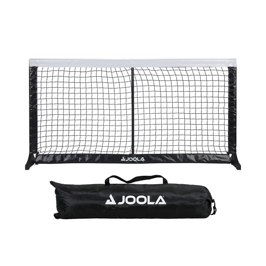 White background, product image of the JOOLA Compact Pickleball net set up with the carrying case next to the net.