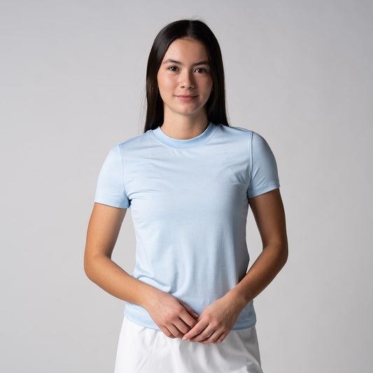 Gray background, female model wearing a JOOLA women's club short sleeve, blue breeze.