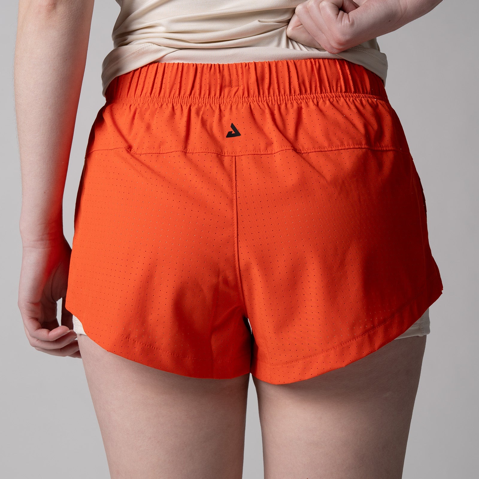 Close up image of the back of a pair of JOOLA women's court 2 in 1 shorts, poppy red.