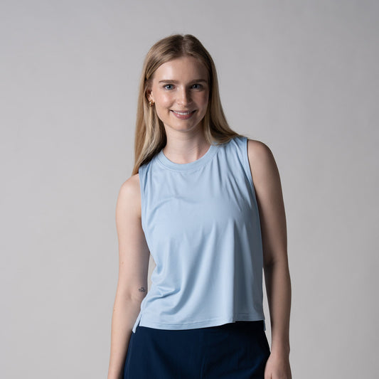 Gray background, image of a female model wearing a women's court tank, blue breeze.
