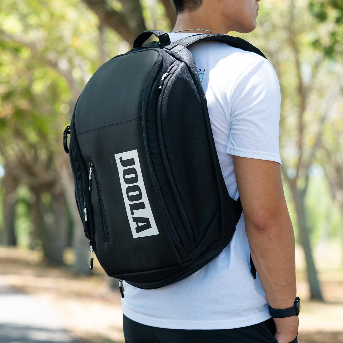Close up image of the JOOLA Vision II Backpack on the shoulders of a male model.