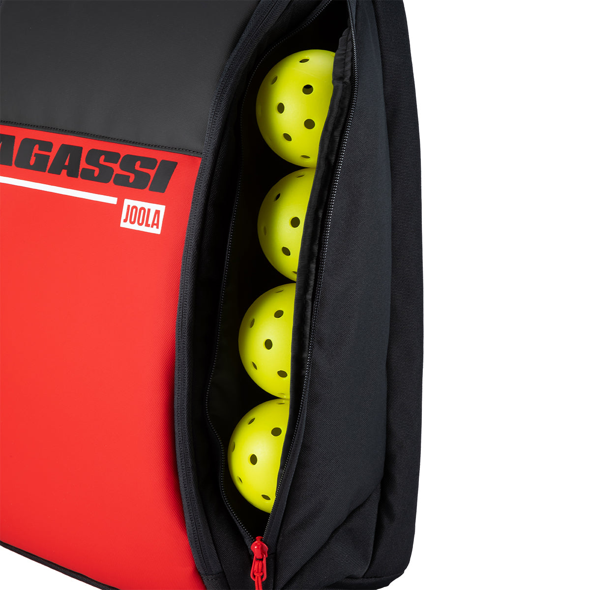White background, close up image of four JOOLA pickleballs in the side pocket of the Agassi Vision II deluxe backpack.