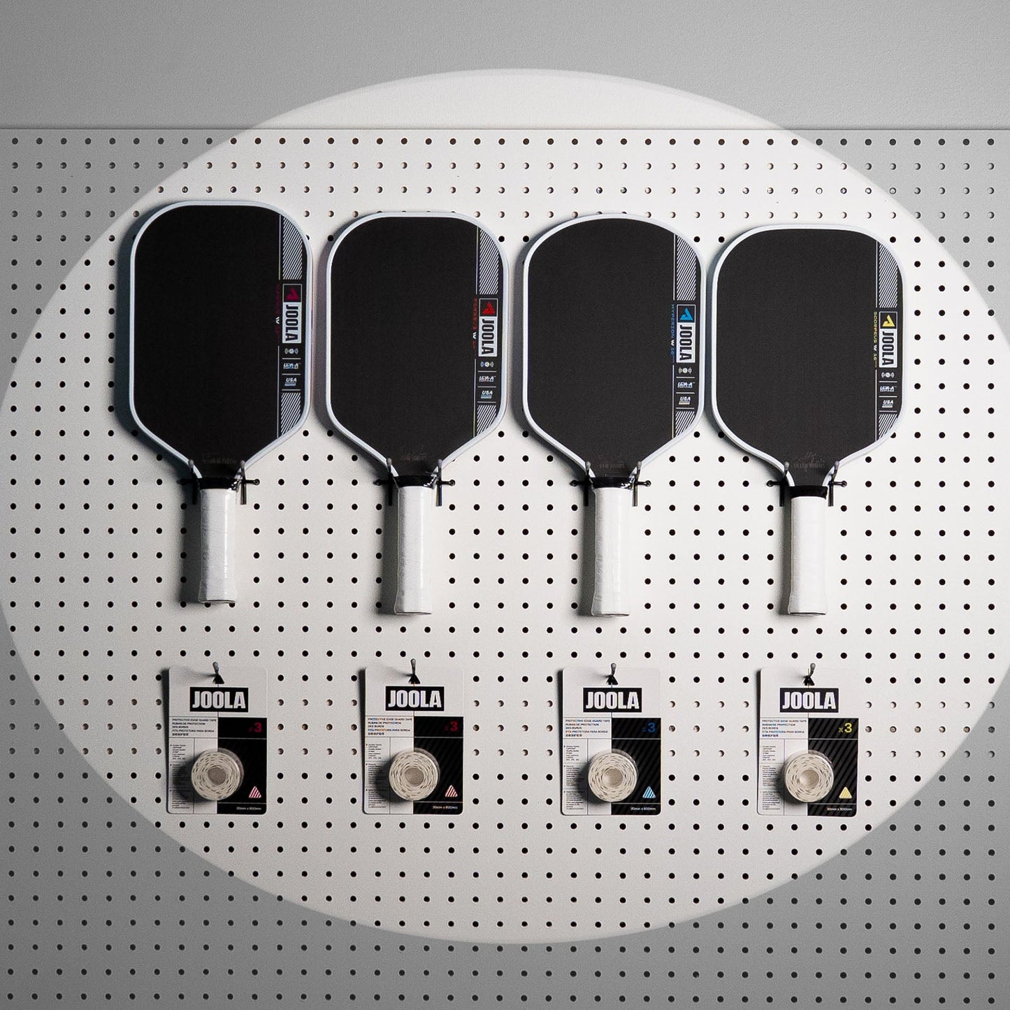 Fourn JOOLA Pro IV pickleball paddles on a pegboard with a package of Pro IV edge gaurd tape below each paddle.